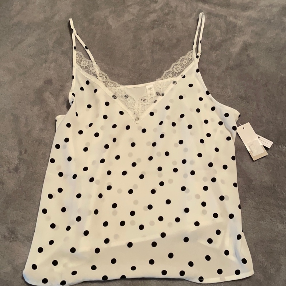 Polka dot cream and black top with lace accent.